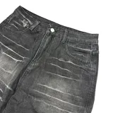 Pantalón de jean estilo baggy fit, color negro con efecto lavado y detalles de roturas horizontales en la parte frontal. Presenta un corte holgado y tiro bajo.
