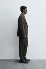 Blazer de corte regular confeccionada en tejido de lana. Presenta cuello con solapas de muesca, cierre frontal de un botón y manga larga con puños abotonados. Cuenta con bolsillos de vivo en el pecho, bolsillos con solapa en la cadera y aberturas en la parte posterior.