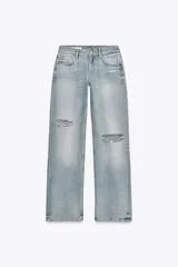Jeans de tiro bajo, pierna ancha y largo completo, color celeste claro con efecto desgastado y rotos a la altura de las rodillas.