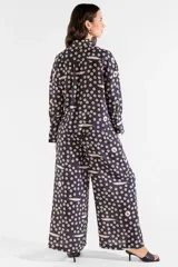 Pantalón ancho negro con estampado de círculos y sardinas en color crema, de tiro alto, corte fluido y elástico en la cintura con bolsillos laterales.
