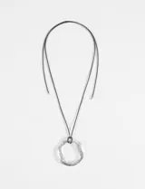 Collar con cordón negro ajustable y dije grande de forma abstracta en tono plateado.