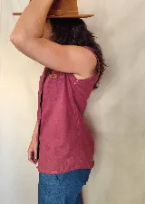 Musculosa tipo camisa con cuello camisero, cierre frontal de botones y dos bolsillos delanteros en el pecho. Diseño a rayas verticales en tonos celeste y blanco.
