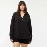 Camisa negra de punto crepé con cuello en V y botones frontales.