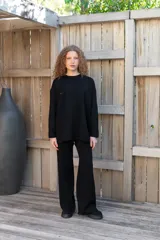 Conjunto de dos piezas color tostado, compuesto por un buzo de cuello redondo con mangas largas y hombros caídos, y un pantalón de corte recto con cintura elástica y cordón ajustable.