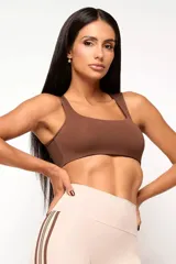 Top deportivo de entrenamiento con escote redondeado y espalda tipo nadador, confeccionado en poliamida tecnológica de alto rendimiento. Cuenta con forro interno y abertura para colocar almohadillas.