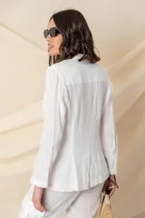 Blazer blanco de lino, corte clásico, con solapas de muesca, cierre frontal con un botón forrado y bolsillos ojal.