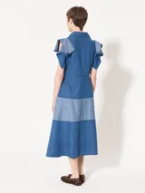 Vestido camisero midi de denim azul con silueta relajada. Tiene mangas cortas rebatidas, recorte a contratono en la falda y acceso frontal con botones.