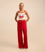 Pantalón de corte pantalona ancho, color rojo vibrante, confeccionado en viscosa y lino. Presenta un lazo de tela para atar en la cintura.