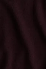 Buzo de punto fino color bordó, con escote off-the-shoulder y hombros caídos. Tiene mangas largas y remate acanalado en puños y bajo.