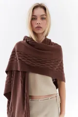 Ruana de punto color beige con detalles texturizados y tramados abiertos, ligera y versátil.