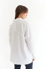 Camisa de corte oversize color bordó, con cuello clásico, cierre frontal de botones y detalle de trenzado horizontal en la parte superior delantera. Posee mangas largas con puños abotonados.