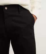 Pantalón slim de sarga color gris, con cintura con trabillas, cierre de botón y cremallera, y bolsillos laterales y traseros.