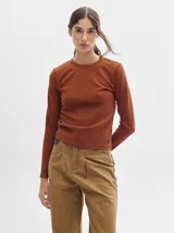 Remera de manga larga con cuello a la base, confeccionada en tejido acanalado con calce al cuerpo y diseño tipo crop.