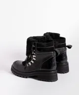 Borcegos de cuero vacuno en tonos marrón, con diseño de caña media y cuello con forro de piel sintética negra. Presentan cordones marrones, ganchos metálicos para ajuste y suela de goma tipo track con plataforma.