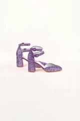 Zapatos de tacón color lila con glitter, punta redondeada y doble tira con hebilla en el tobillo.