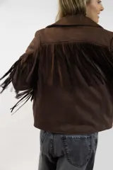 Campera marrón de gamuza sintética con flecos colgantes en la espalda y mangas, solapas anchas y cierre frontal.