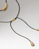Collar PDPAOLA modelo Orbit con cordón negro y dije central dorado de diseño orgánico.