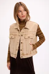 Chaleco de denim con lavado desgastado, corte relajado, cuello camisero y cierre frontal con botones metálicos. Presenta bolsillos frontales con solapa y costuras reforzadas.