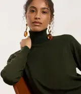 Aros colgantes de diseño maxi, compuestos por una base de media esfera con baño dorado y colgantes de resina en tono ámbar con detalles metálicos dorados.