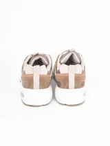 Zapatillas deportivas de estilo urbano, color blanco con detalles en plateado, confeccionadas en malla y material sintético, con suela de goma.