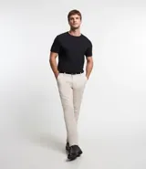 Pantalón de vestir para hombre, corte slim, color beige claro, confeccionado en sarga de algodón con elastano. Presenta cierre frontal con botón y cremallera, bolsillos laterales y traseros.