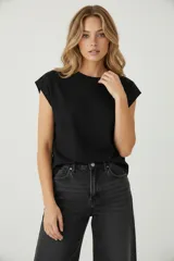 Remera negra de algodón, de corte holgado, con cuello redondo a la base y mangas cortas tipo 'cap sleeve' o al hombro.