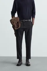 Pantalón chino de corte slim fit, confeccionado en tejido elástico. Presenta bolsillos frontales, bolsillos traseros de vivo con botón y cierre frontal con cremallera y botón.