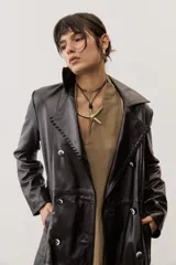 Chaqueta negra de cuero con cuello camisero, mangas largas y costuras decorativas.