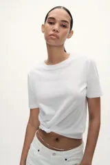 Camiseta básica de cuello redondo y manga corta, confeccionada en tejido de algodón liso.