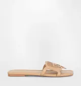 Sandalias planas color beige con detalle de logo de ojo en la tira superior.