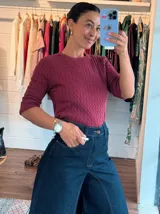 Pantalón de jean tiro alto con corte elefante, caracterizado por su silueta amplia y acampanada desde la cadera. Presenta cierre frontal con botón y costuras reforzadas.