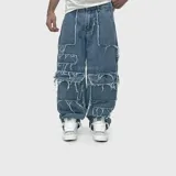Pantalón jean ultra baggy de color azul, confeccionado en denim de algodón. Presenta un diseño cargo con múltiples bolsillos aplicados y detalles de bordes deshilachados en toda la prenda.