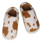 Pantuflas sin talón confeccionadas en algodón afelpado con estampado de vaca en tonos blanco y marrón, con suela de PVC.