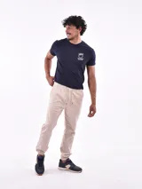 Pantalón tipo jogger de gabardina, con cintura elástica ajustable mediante cordón y puños elásticos en los tobillos.