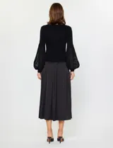 Conjunto de dos piezas compuesto por un vestido midi de satén con breteles finos y un buzo de punto acanalado con mangas largas abullonadas de textura semitransparente.