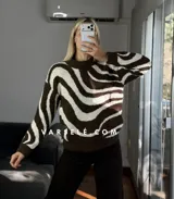Sweater de tejido de punto con diseño de ondas en color marrón y crema, de cuello redondo y manga larga.