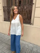 Musculosa de color beige, con escote en V y diseño sin mangas de corte holgado.