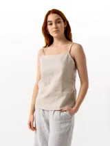 Top sin mangas color beige, de lino, con breteles finos regulables, escote recto y cierre lateral invisible.