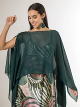 Capa midi verde oscuro confeccionada en gasa, con diseño asimétrico más corto en la parte delantera y más largo en la trasera, de caída liviana y fluida.