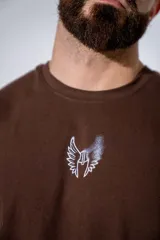 Remera oversize de algodón elastizado color marrón, con corte holgado y diseño de alas pequeñas estampado en el centro del pecho.