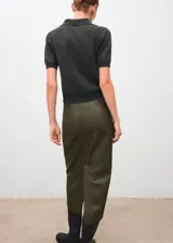 Jersey de punto fino color gris oscuro, de manga corta, con cuello polo y cierre frontal de botones.