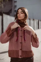 Saco de punto vanizado, tejido en dos colores con efecto bicolor a rayas verticales, cuello redondo, manga larga y cierre frontal con botones negros.