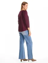 Buzo de tejido fino color violeta, con mangas tres cuartos y corte dolman. Presenta un diseño de textura geométrica sutil en el frente y cuello redondo.