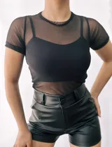 Remera de tul negra de manga corta con cuello redondo, que incluye un top negro de breteles finos.
