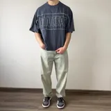 Remera gris oscuro de corte boxy y mangas cortas, con un gran estampado frontal en el pecho que dice "CONCEPT" en líneas blancas.
