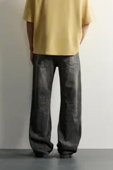 Jeans flare fit de denim de algodón en color gris con efecto lavado. Presentan diseño de cinco bolsillos, tiro medio y cierre frontal con cremallera y botón.