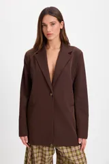 Blazer de corte sastrero en color marrón chocolate, con solapas clásicas, cierre frontal de un botón y bolsillos laterales con solapa.