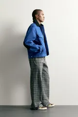 Cazadora cropped fit de algodón azul con efecto lavado, cuello solapa negro en contraste, cierre frontal con cremallera y bolsillos de plastrón con solapa en el pecho.