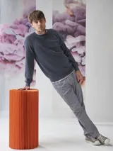 Sweater de algodón con cuello redondo, diseño de tejido combinado con textura acanalada en la parte superior y bolsillo frontal pequeño con etiqueta decorativa.