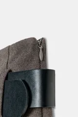 Falda pantalón gris de tiro medio con pliegues delanteros y cinturón ancho negro con hebilla plateada. Cierre lateral con cremallera oculta.